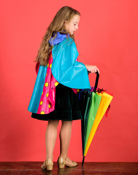 小朋友女孩开心的撑着五颜六色的伞穿防水斗篷。穿着合适的衣服享受雨天。防水配件，雨天愉快愉快。防水配件制造图片下载