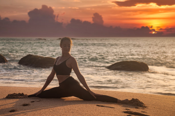 年轻女性瑜伽姿势劈叉或缠绕健康的生活方式在热带海岸或海洋海滩户外图片下载