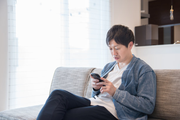 一个在客厅用智能手机的男人图片下载