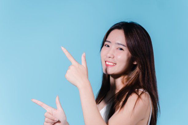 迷人的亚洲美女持有防晒霜和颜色规模与防晒紫外线或防晒霜的蓝色背景图片下载