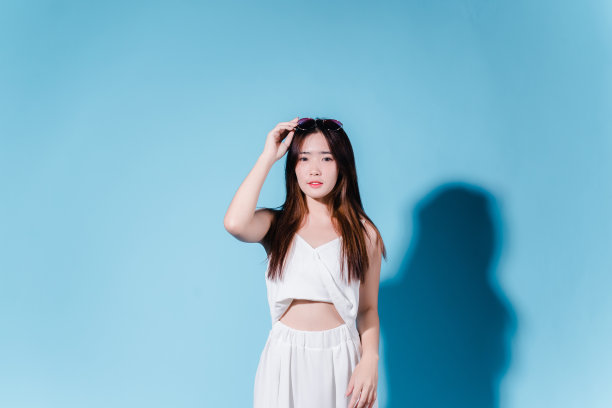 迷人的亚洲美女持有防晒霜和颜色规模与防晒紫外线或防晒霜的蓝色背景图片下载