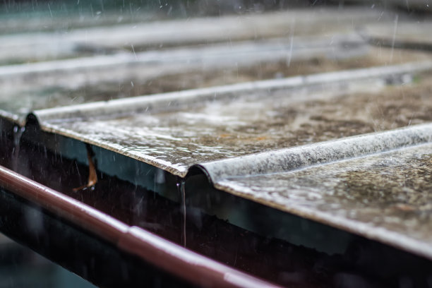 雨水从人行道上的绿色排水沟中倾泻而下，选择性集中。图片下载