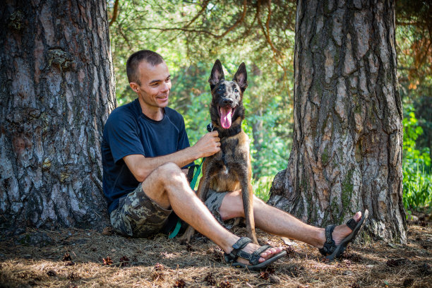 年轻的白人潮人在一个阳光明媚的夏天和他的狗在公园里消磨时间。宠物作为家庭成员的概念图片下载