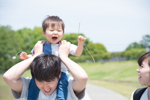 年轻的亚洲三口之家肩上扛着一个孩子散步图片下载