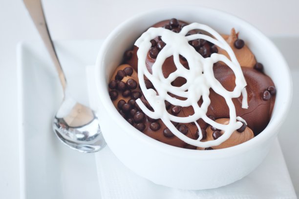 奶油泡芙，点缀着白巧克力格子，盛在银色的陶瓷碗里图片下载