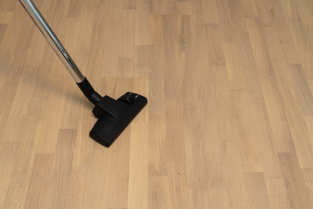 真空吸尘器在天然拼花地板背景与复制空间。打扫屋子。图片下载