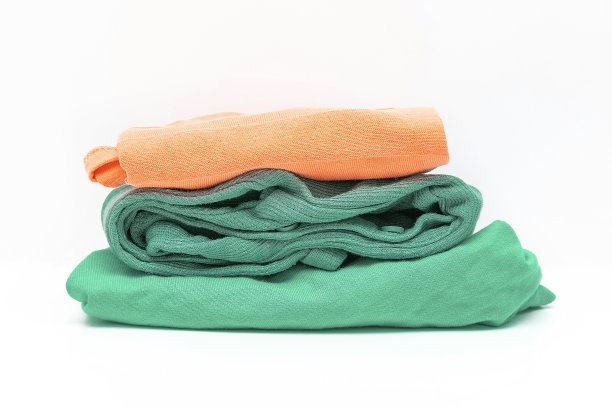 洗衣店将浅色粉彩橙色和绿色女性服装分开。堆叠三色保暖的衣服毛衣近。最小的时尚概念。家里的衣柜。时尚女性的看图片下载