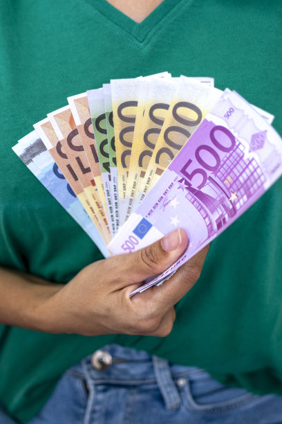 女人手里拿着钱。现金以欧元支付或兑换。女性用欧元钞票计算工资。存钱，取银行存款。欧洲单一货币。图片下载