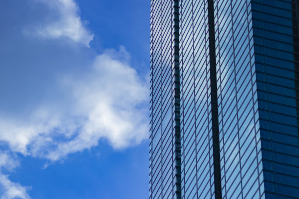 从远处看，一片云彩反射出商业区的大楼图片下载