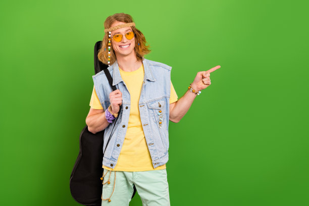 照片的家伙旅行者民谣摇滚拿吉他点空空间广告穿牛仔裤时髦背心孤立闪亮的颜色背景图片下载