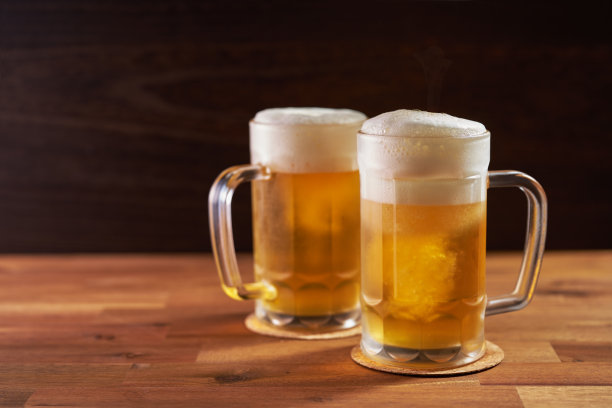 清爽的冰啤酒杯在木制背景图片下载
