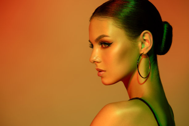 华丽的侧面，长而优雅的脖颈，准确地挽成发髻，妆容生动。时尚女人的肖像。图片下载