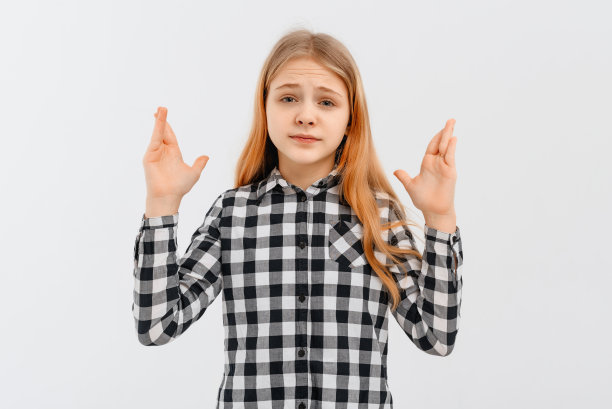 沮丧的十几岁女孩举起双手沮丧和失望，站在白色背景休闲衬衫。室内工作室拍摄的白色背景图片下载