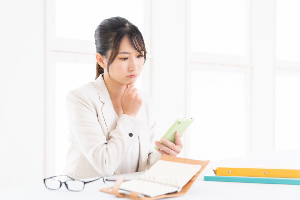 年轻的亚洲女性看到智能手机，会想，图片下载