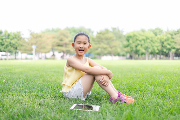 小学生坐在草地上图片下载
