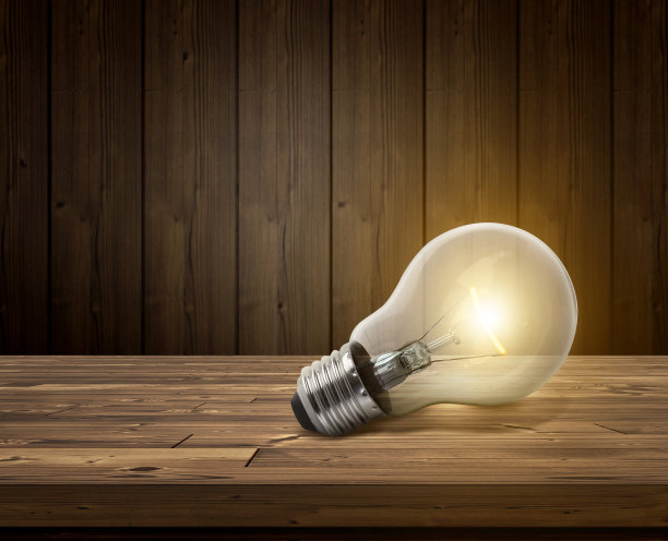 白色的灯泡在木地板上发光图片下载