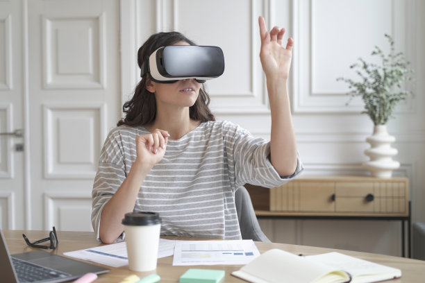 年轻专注的女性戴着虚拟现实头盔，在工作中360度观看内容图片下载