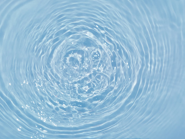 散焦模糊透明蓝色，清澈平静的水面纹理与飞溅和气泡。时髦的抽象自然背景。水在阳光下起伏。水蓝色背景。图片下载