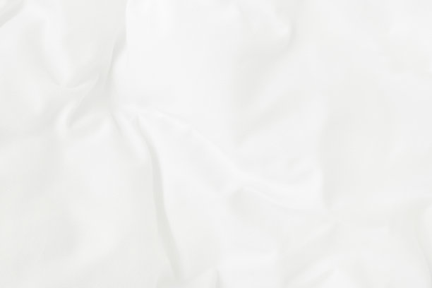 白色的毛毯和被单在睡醒后的卧室里有褶皱或凌乱的纹理。图片下载