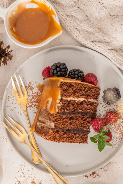 美味的半裸巧克力蛋糕，点缀着焦糖，点缀着黑莓和覆盆子。光背景图片下载