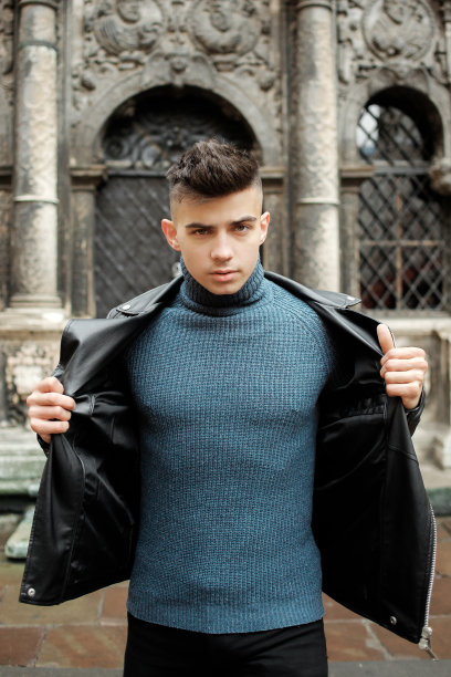 11月2日，在乌克兰利沃夫，一名英俊的小男孩在一扇黑门前摆姿势。图片下载