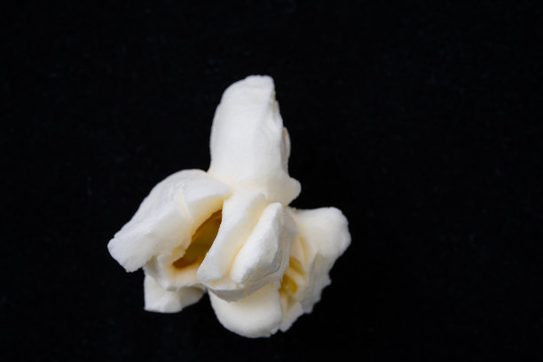 极端特写照片的一个异想天开的人物爆米花在黑色背景，一个孤立的爆米花的图像。图片下载