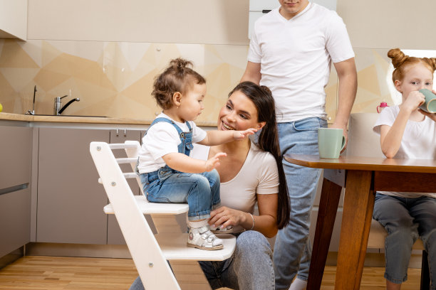 可爱的宝宝坐在餐桌旁，在厨房吃饭图片下载