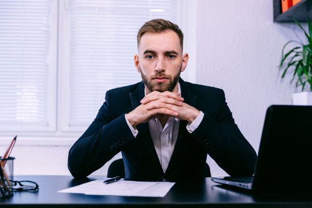 自信的商人手里拿着笔记本电脑和文件图片下载