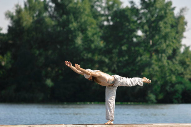 日出时，一个年轻人在户外的河边泊位上练习瑜伽。自我意识和接受。心理健康理念，放松身心，与自然和谐相处图片下载