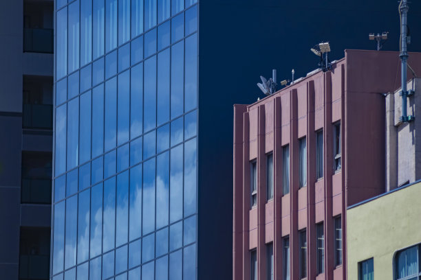 从远处看，一片云彩反射出商业区的大楼图片下载