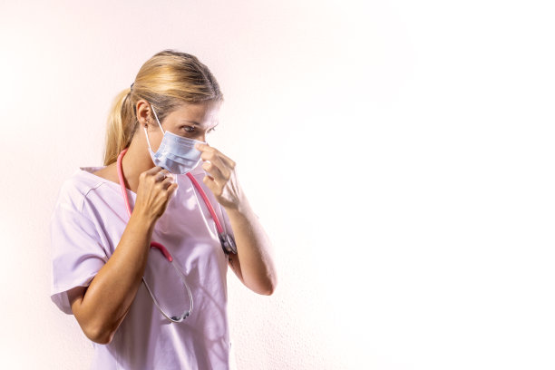 医女在调整她的外科口罩健康的概念。冠状病毒新型冠状病毒肺炎大流行。猴痘。图片下载