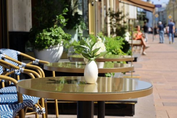 城市的街头咖啡馆，户外的空桌子上行走的人的背景图片下载