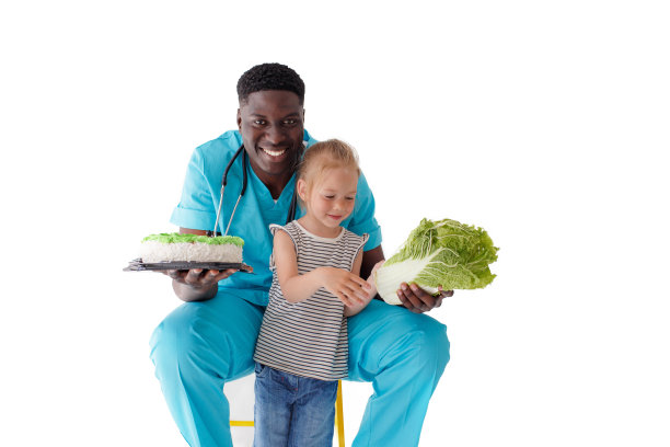 一位非洲裔美国医生拿着蛋糕和卷心菜，给一个小孩讲健康和正确的营养。健康饮食的概念。图片下载
