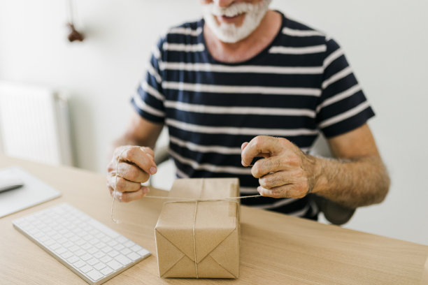 在网上商店工作的高级男子的特写。Covid-19大流行期间的远程办公。小企业主图片下载