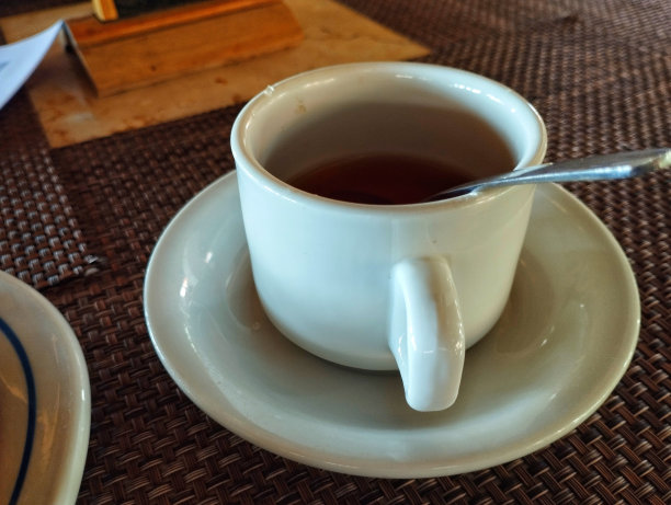 茶杯和勺子。白玻璃杯里的红茶图片下载