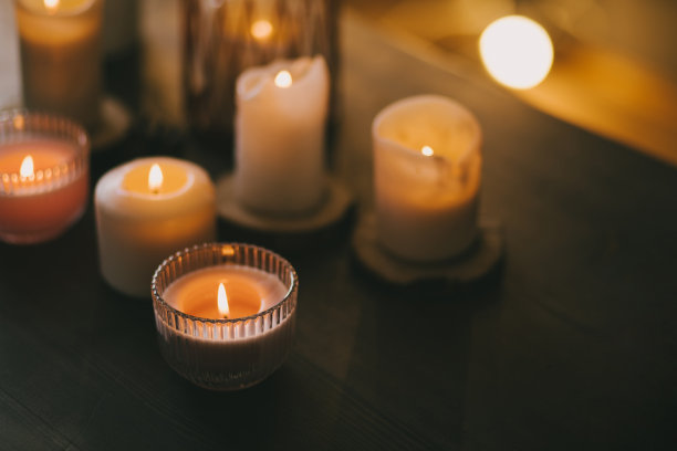 木桌上的玻璃杯里放着蜡烛。图片下载