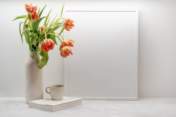 新鲜的郁金香，杯子，书和框架在桌子上图片下载