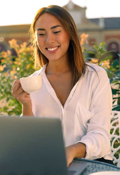 穿着白衬衫的快乐女人在咖啡馆远程工作图片下载