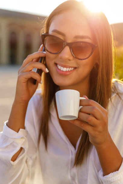 一个年轻女人在咖啡馆接电话图片下载