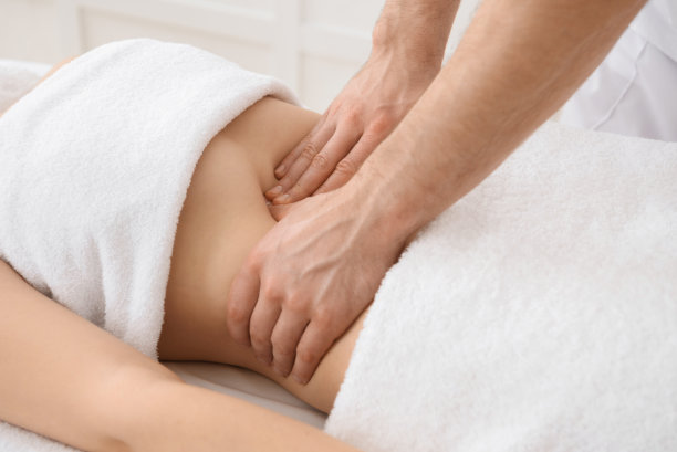 白色背景，复制空间，整骨医生在女性腹部做推拿的特写图片下载