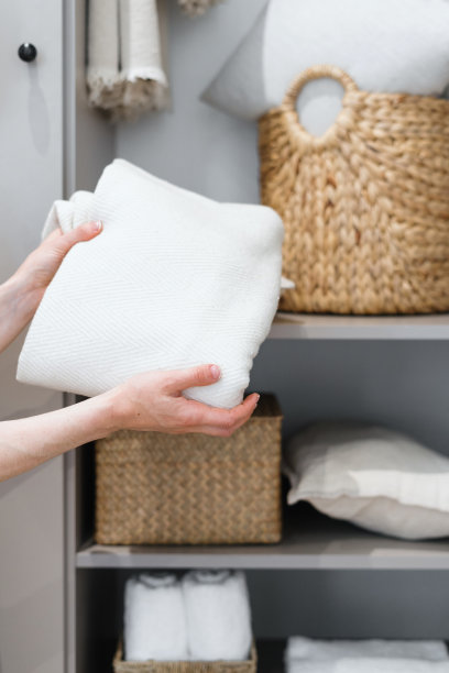 在舒适的房间里，女人拿着新鲜的白毛巾图片下载