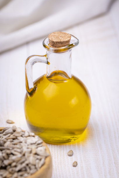 装有黄色油性液体的玻璃瓶。特写向日葵植物油。图片下载