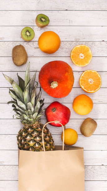 环保购物袋与外来水果的木制背景。平铺夏日美食概念图片下载
