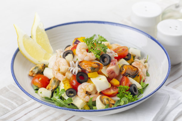 意大利什锦海鲜沙拉。Insalata di母马。鱿鱼，虾，蛤，番茄，甜椒，欧芹和橄榄。图片下载