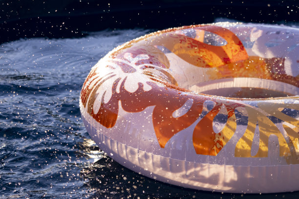 游泳池里漂浮着充气的游泳圈。水花飞溅的特写。夏天的时间。特写照片图片下载