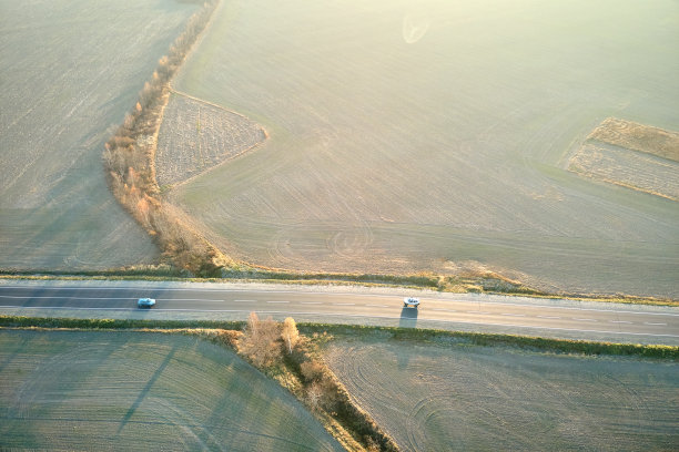 鸟瞰图城际公路与快速驾驶的汽车在日落。无人机在傍晚俯瞰公路交通图片下载