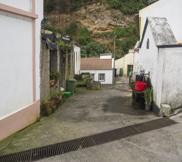 圣米格尔，亚述尔的一个小村庄的院子里的井或喷泉，红黑桶装满了水在街道上的花盆图片下载