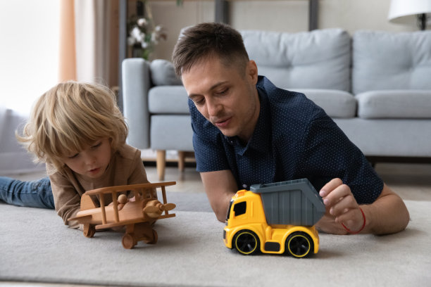 快乐的年轻父亲和小孩玩玩具。图片下载