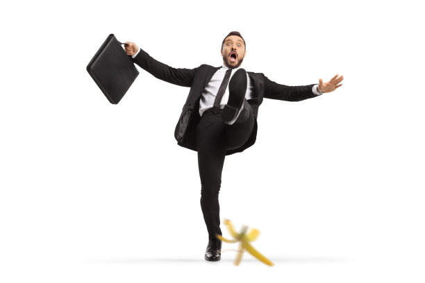 一名震惊的商人的全身像，公文包在香蕉皮上滑倒图片下载