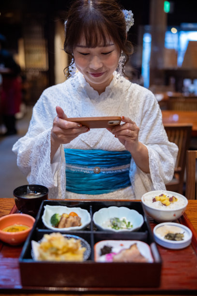 日本女人在夏天的蕾丝和服在日本餐厅拍摄日本食物的照片图片下载